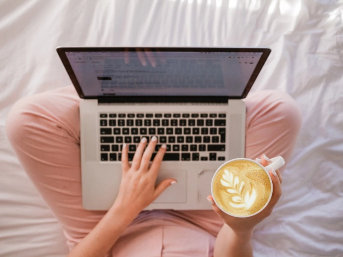 Woman working on a laptop with coffee